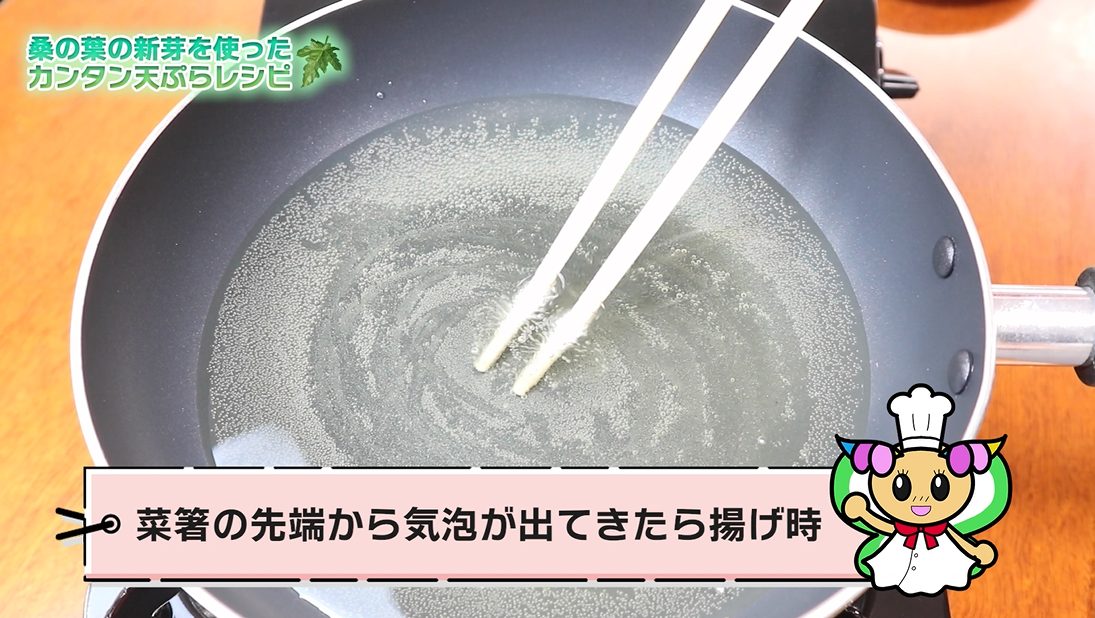 熱した油に菜箸の先端を浸し、揚げ時を確認する様子