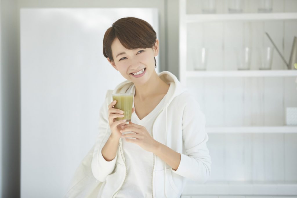 桑の葉茶を持って微笑む若い女性