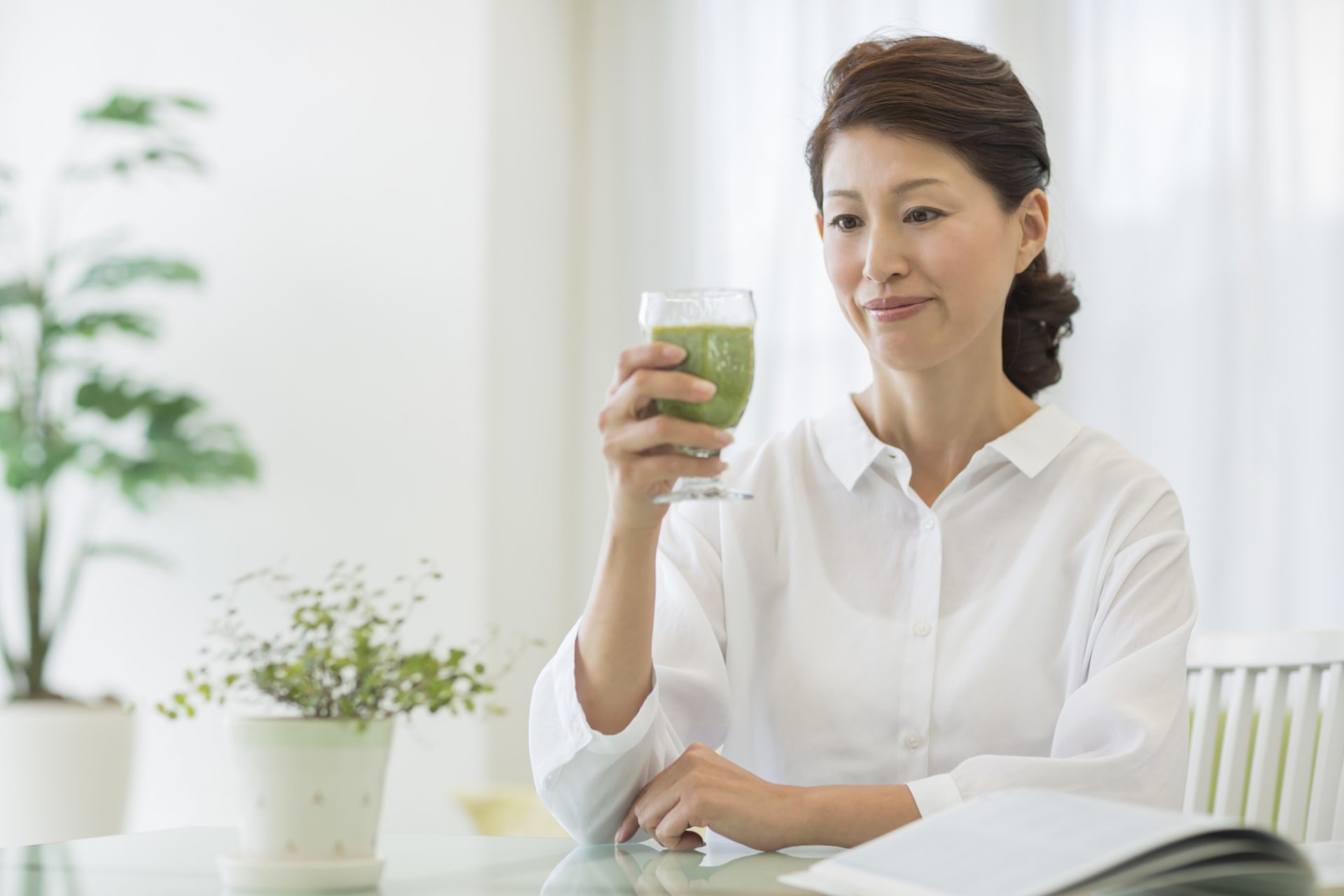 桑の青汁を飲もうとする中年の女性