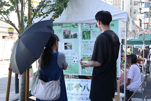 久米川ゼミの展示をご覧になる女性