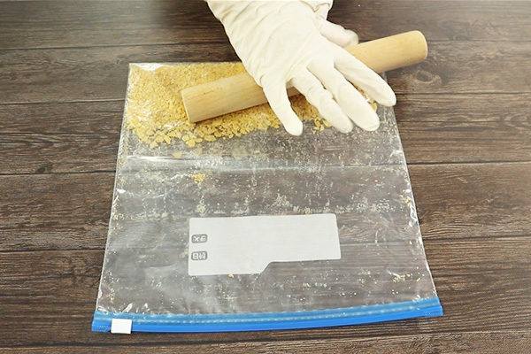 コーンフレークを麵棒でさらに細かく砕く様子
