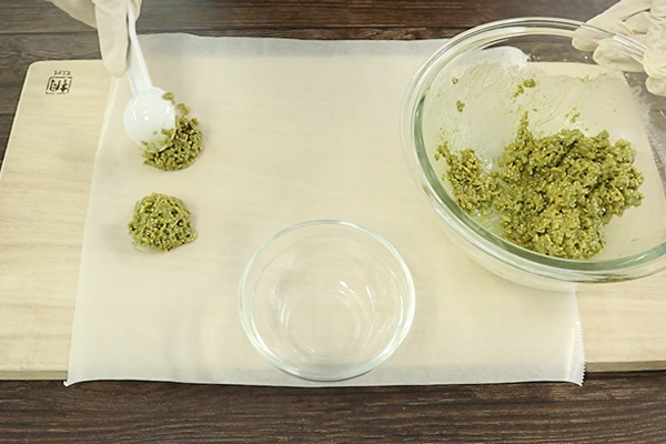 掬ったクランチをクッキングシートの上に出す様子