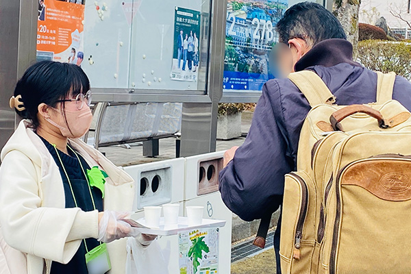 インターン生が桑の青汁の試飲を配る様子