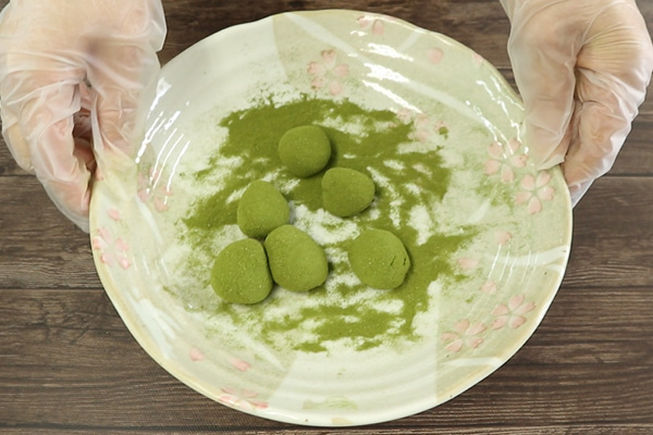 桑ボールに桑の青汁創輝王をまぶす様子